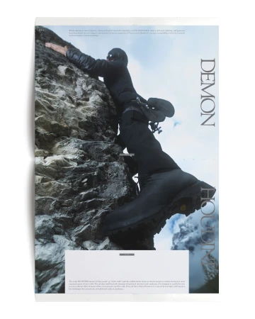 Person in black climbing a rocky cliff face, wearing winter apparel and hiking boots, captured in a mountain environment.