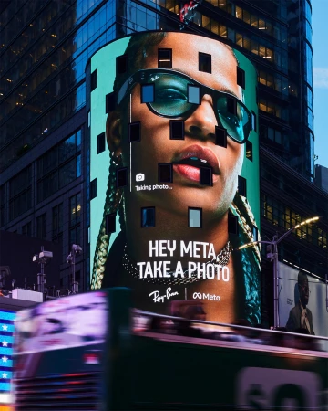 Billboard in Times Square features a close-up of a person wearing sunglasses, promoting Ray-Ban and Meta collaboration, city backdrop.