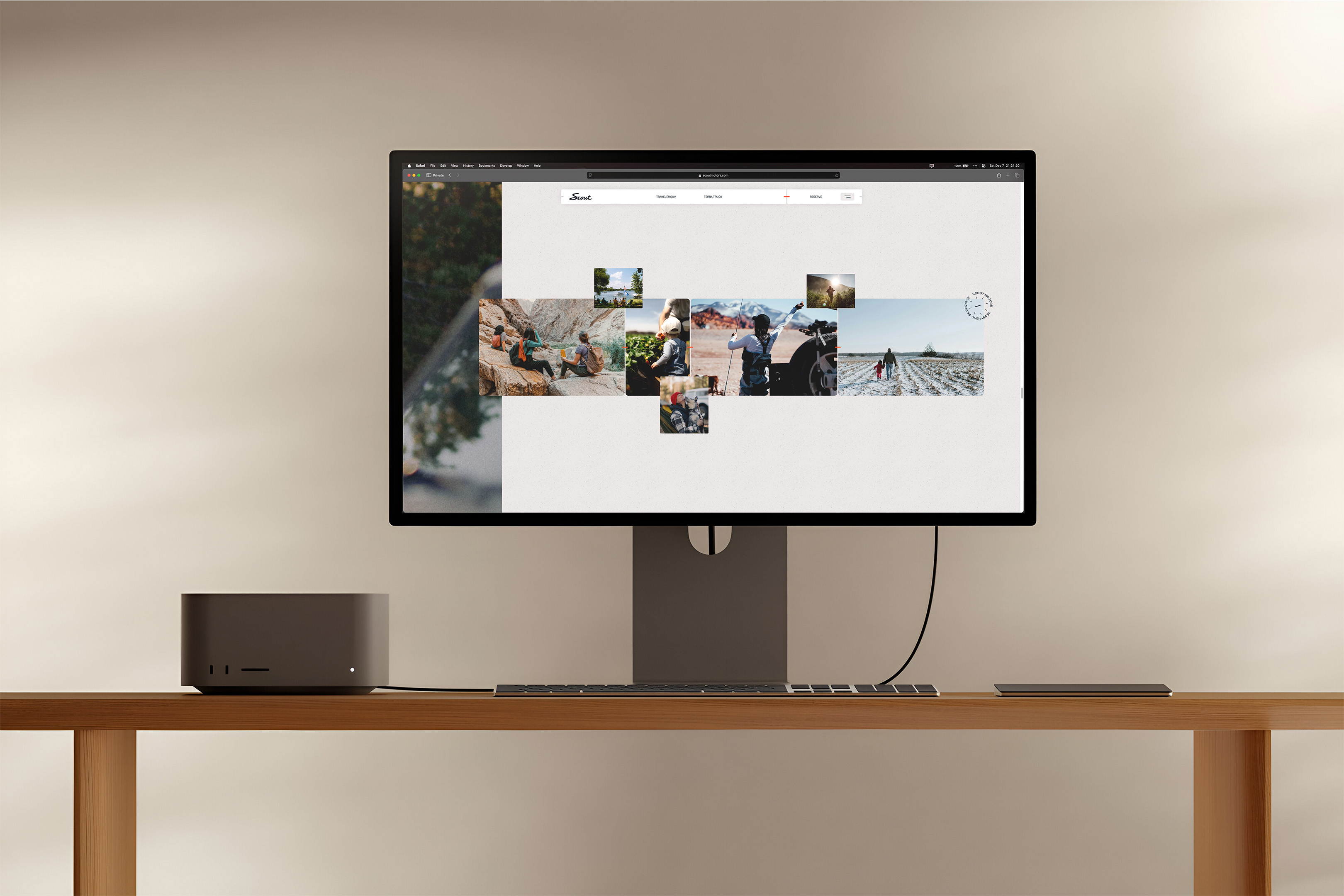 Computer monitor displaying digital photos, next to a desktop computer and keyboard on a light wood table against a neutral wall.