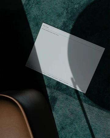 A rectangular sheet featuring the terms 'TOMMY DUNCAN' and 'MICHAEL ABRAHAM CREATIVE DESIGN ADVISOR, DIRECTOR' against a textured green fabric.