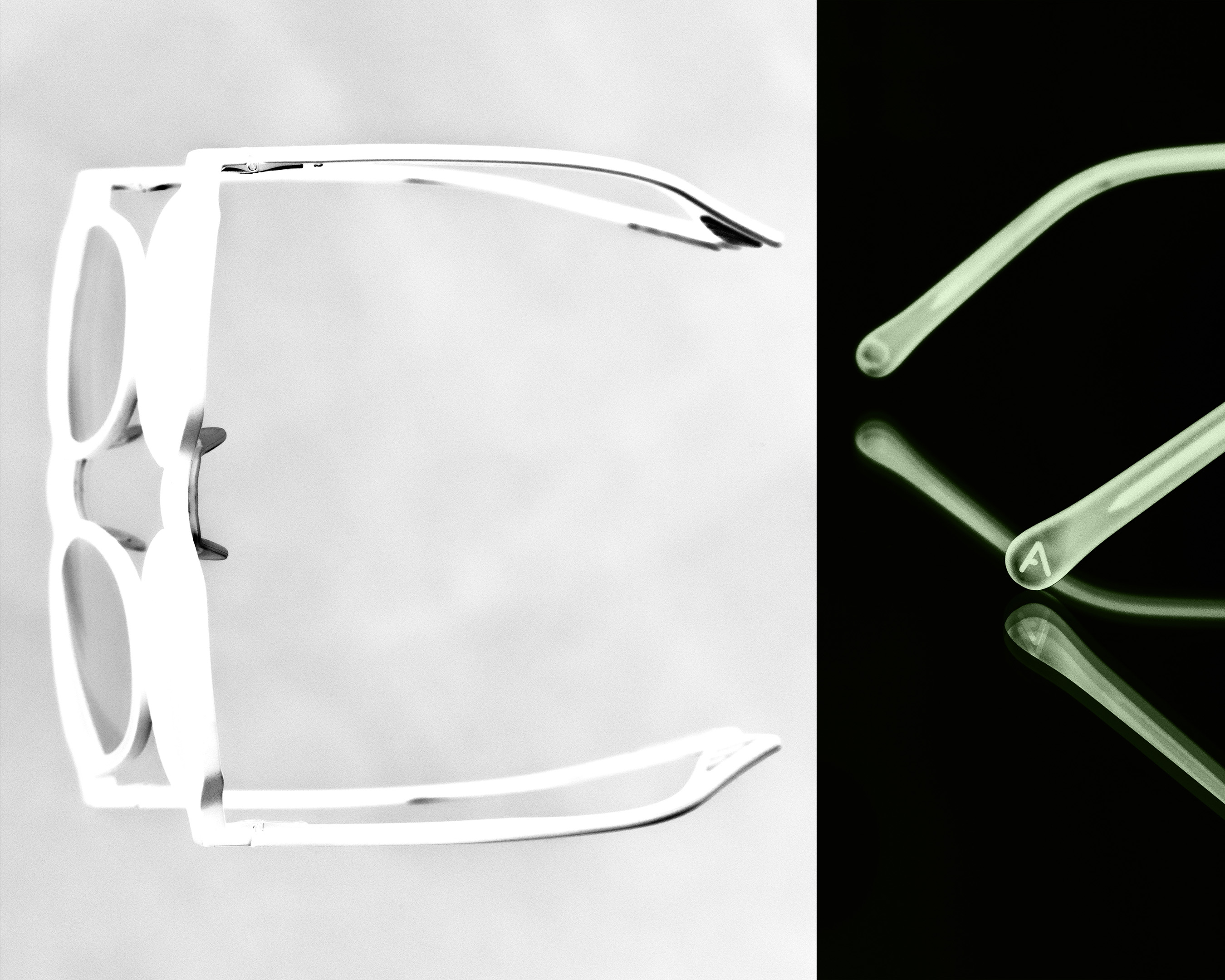 Studio shot of white-framed sunglasses on a split black and white background with reflective surfaces, creating a modern aesthetic.