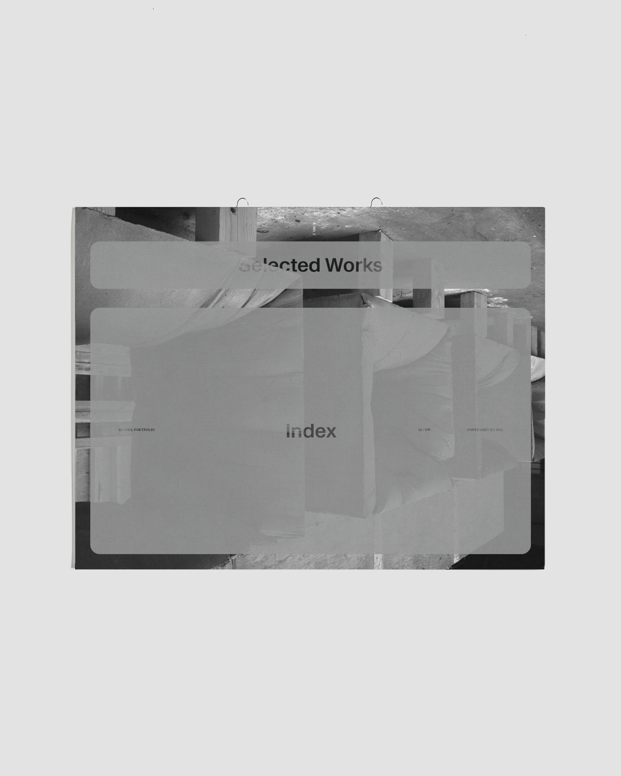 Artistic display of a book-like object on a neutral background, featuring layered text, creating a visually intriguing composition.