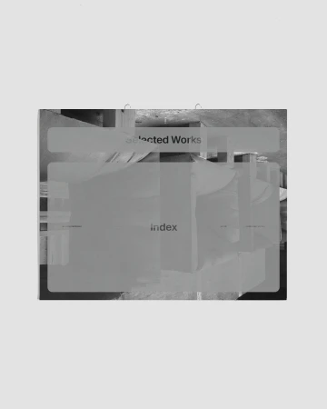 Artistic display of a book-like object on a neutral background, featuring layered text, creating a visually intriguing composition.