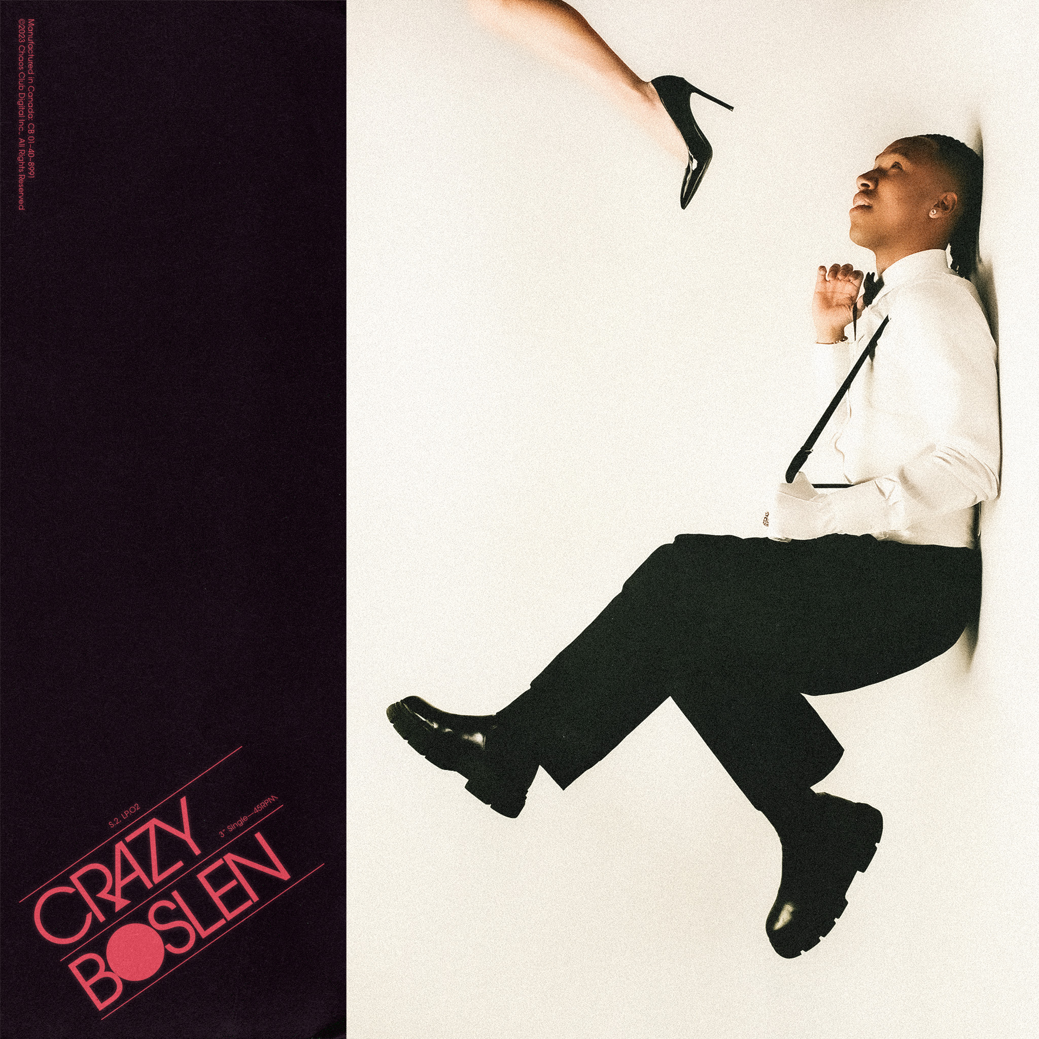 Stylish portrait of a seated man in a suit, accented by a poised stiletto heel, set against a stark white backdrop.