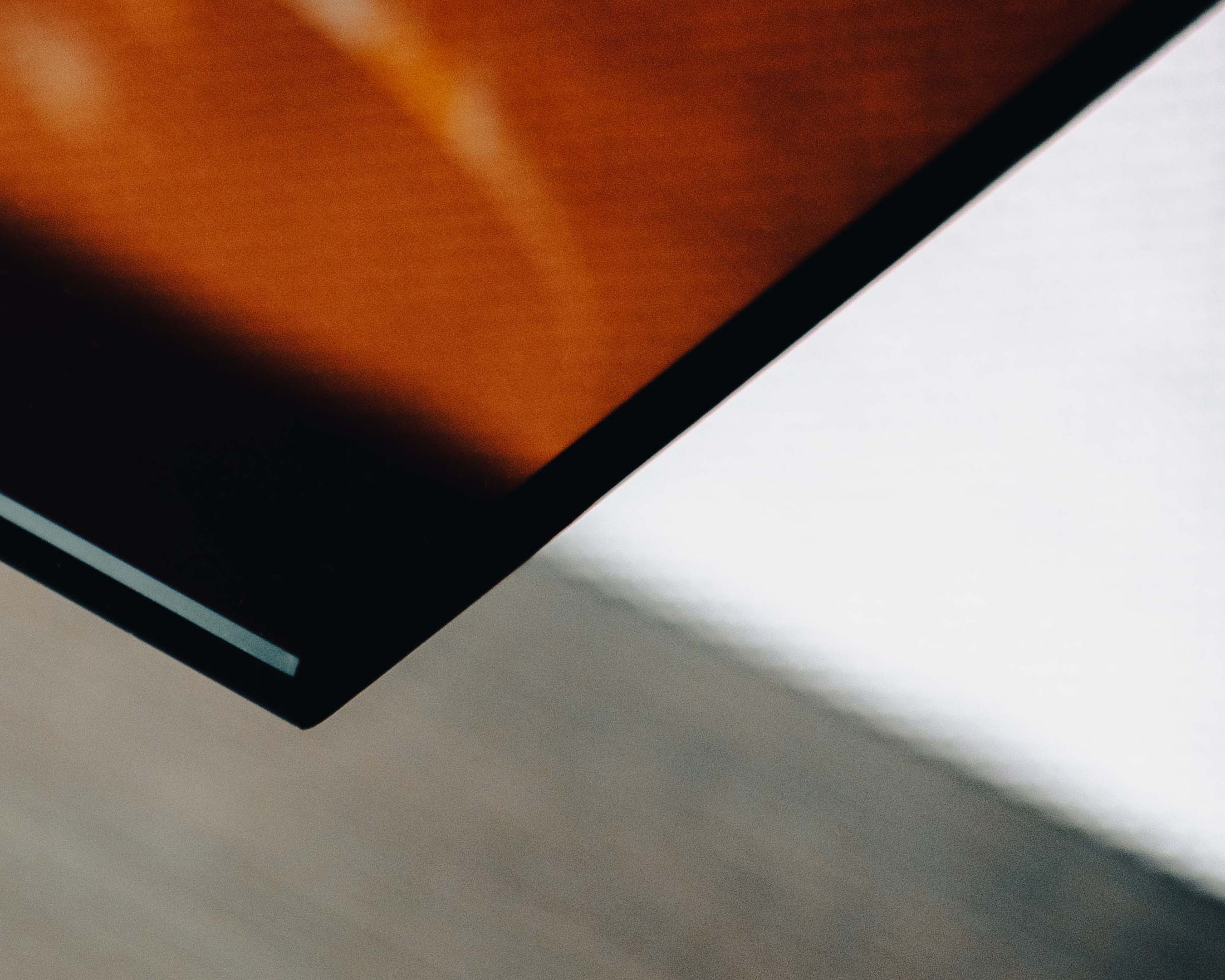 An abstract architectural shot featuring strong diagonal lines and shapes, with a mix of brown, black and white colors in the composition.