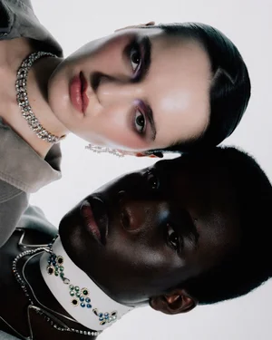Two models wearing layered rhinestone necklaces and embellished chokers against a clean white backdrop.