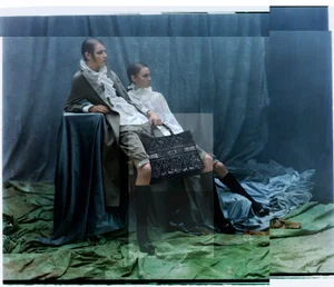 Two models pose among draped blue and green fabrics holding an embroidered Christian Dior tote bag for Dior Magazine.