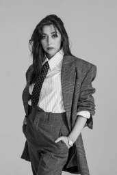 Monochrome portrait of Cristin Milioti wearing an oversized plaid suit jacket, striped shirt, and patterned tie