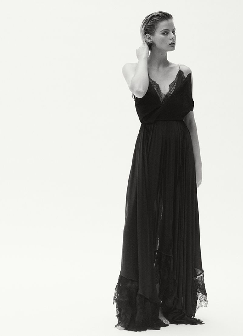 Model Aria Shine wearing a long black lace-trimmed gown against a seamless white studio background for Elle Australia.