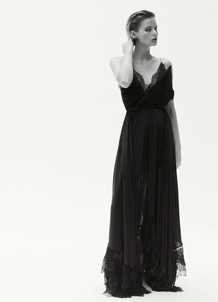 Model Aria Shine wearing a long black lace-trimmed gown against a seamless white studio background for Elle Australia.