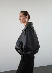 Model wearing a black leather jacket against a minimalist white background for Mango