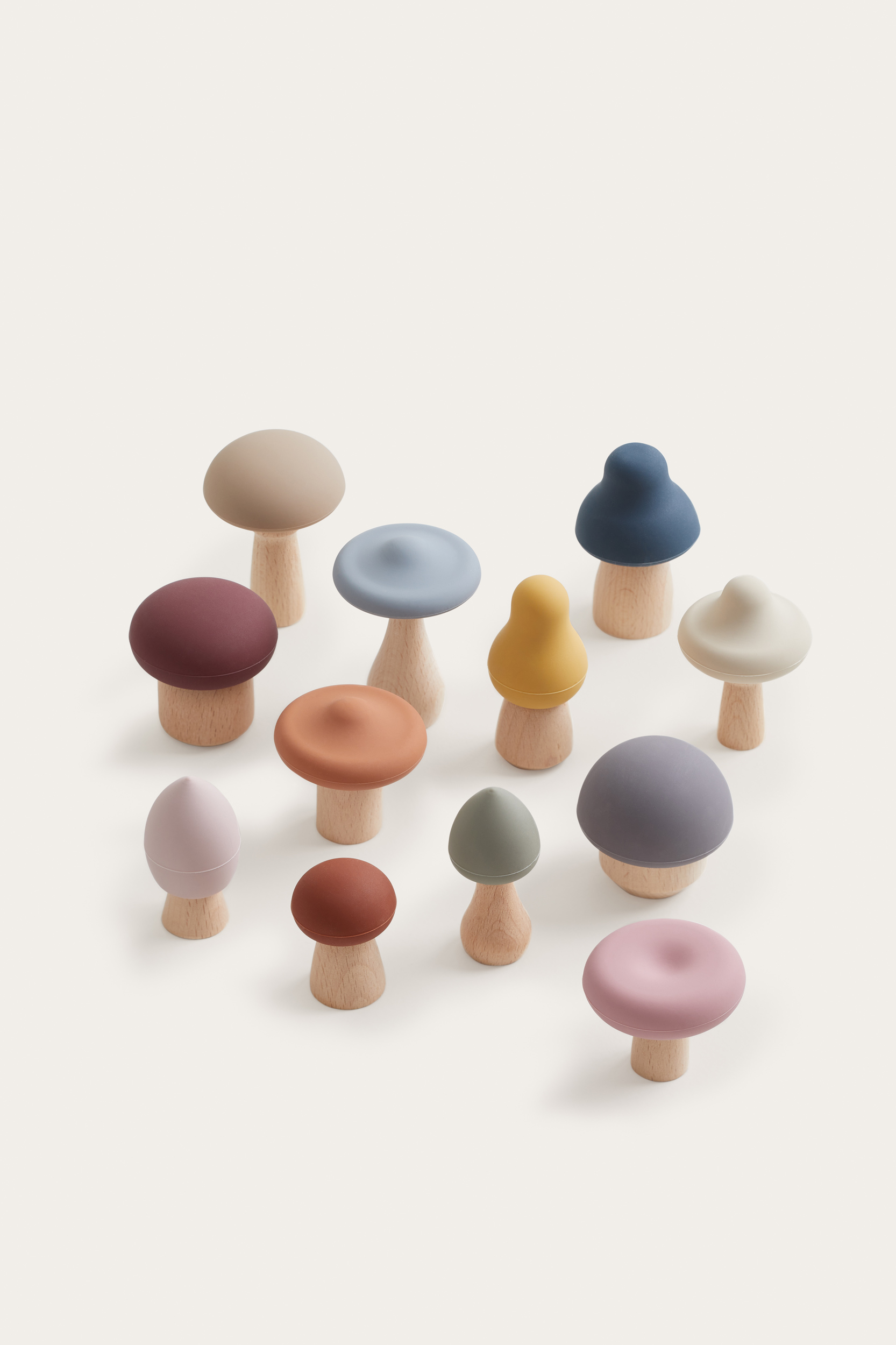 Display of decorative toy mushrooms in a variety of styles, colors, and sizes, set against a light neutral background.