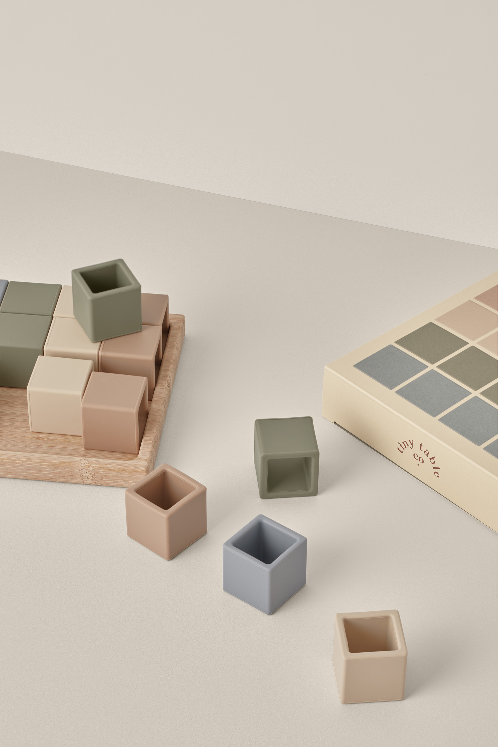 Wooden toy block set on a beige background, featuring muted colors and minimalist design. The toy set promotes early childhood learning.