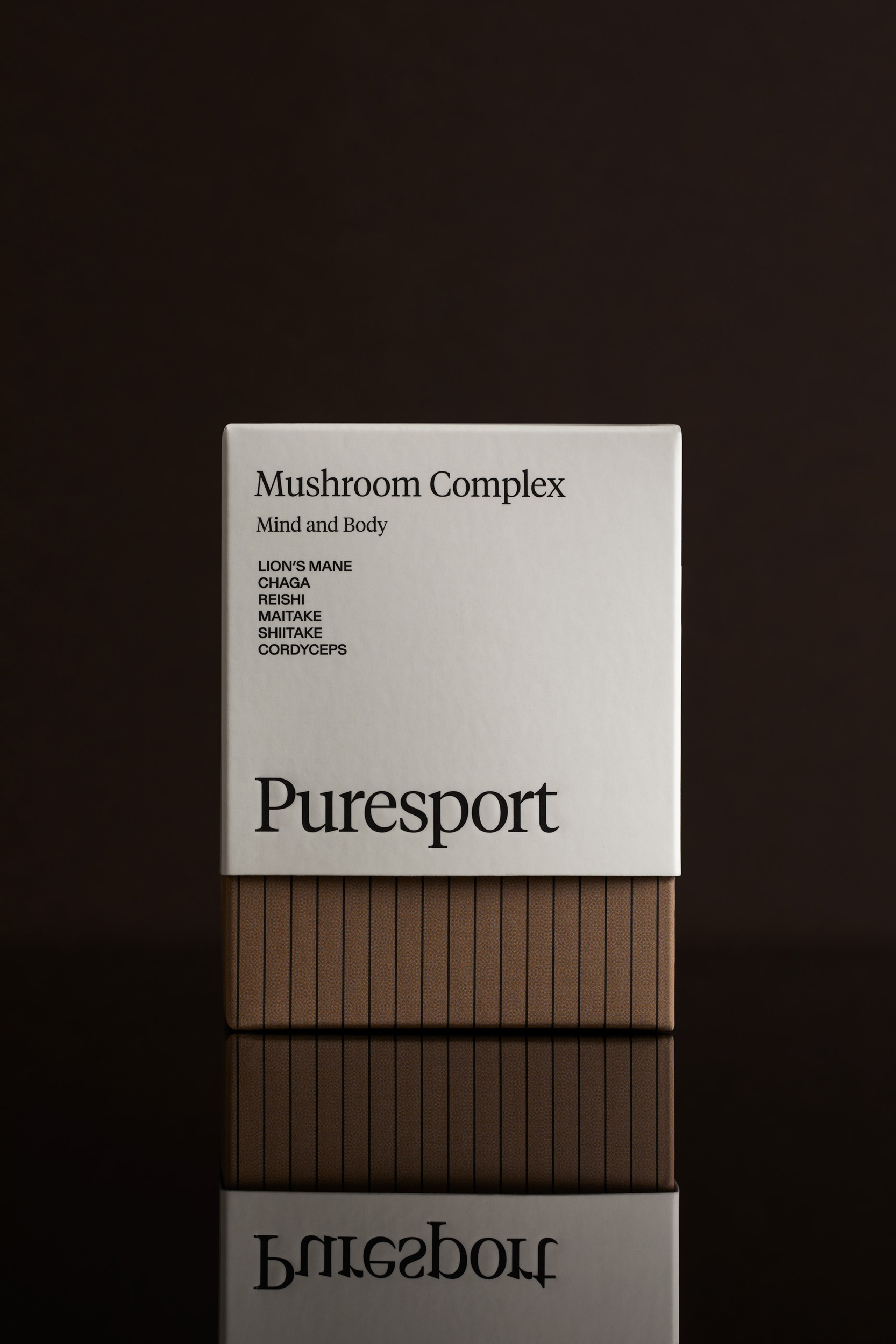 Puresport Mushroom Complex product box on reflective surface against dark backdrop in a studio setting. Health, wellness concept.