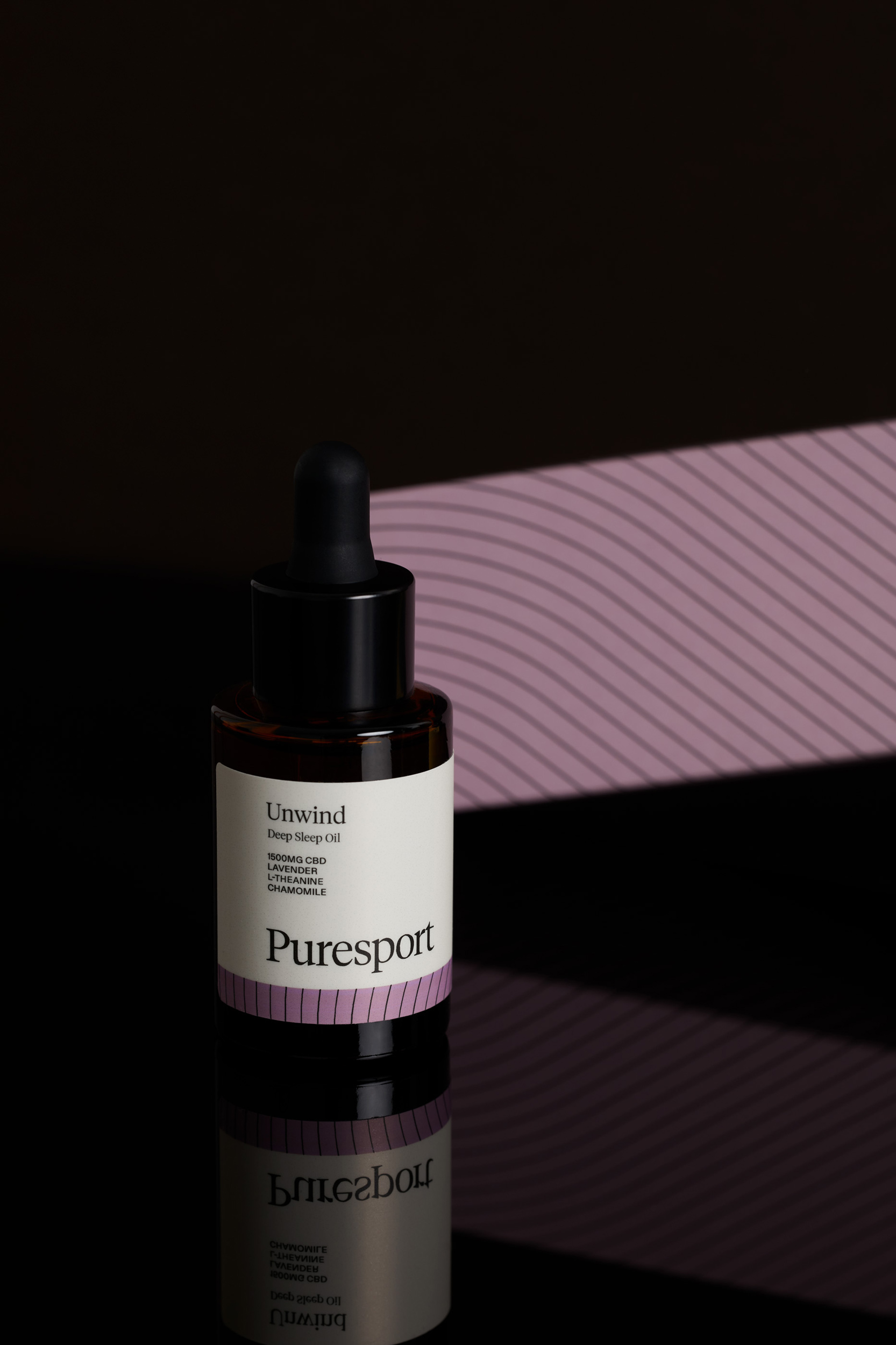 Puresport Unwind Sleep Oil product shot. A dark brown glass bottle sits on a reflective black surface against a textured purple backdrop.