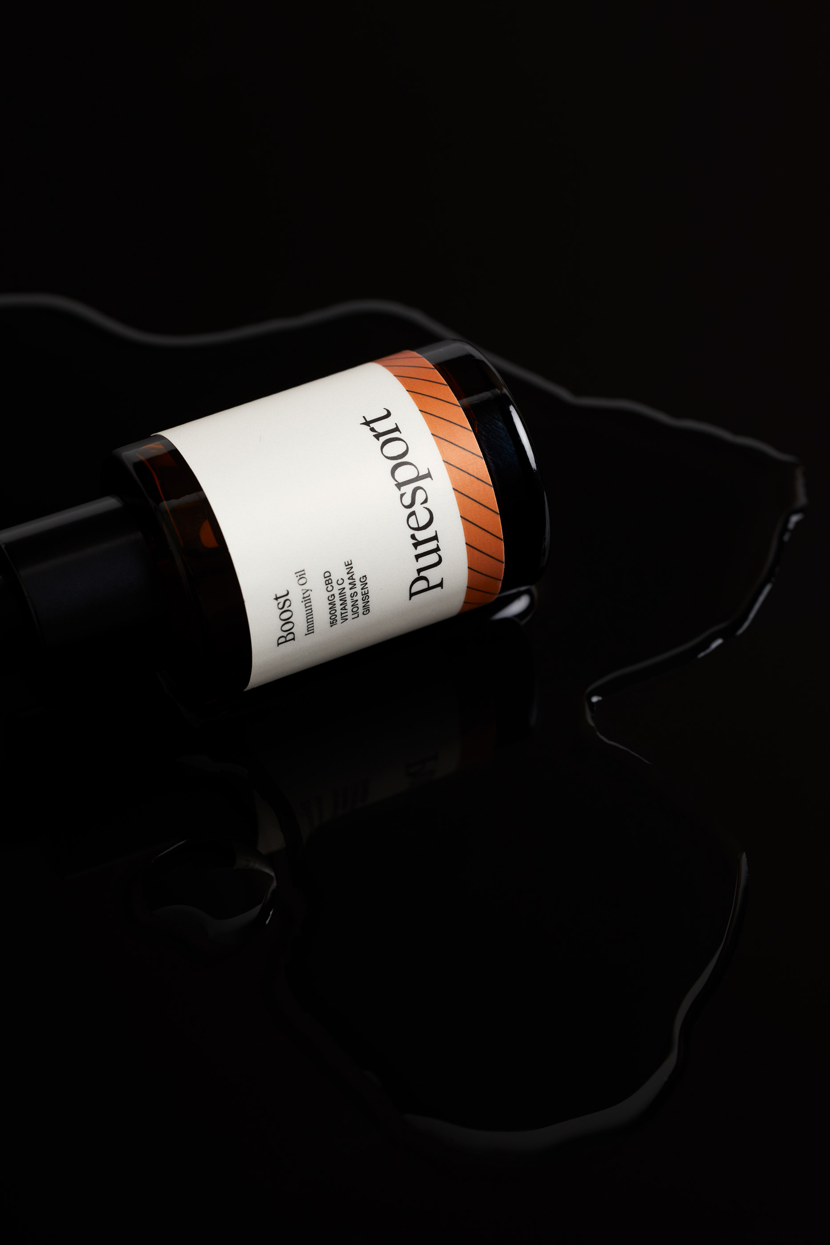 Elevated still life shot of a Puresport boost bottle on a wet black surface, showcasing the product's packaging and brand.