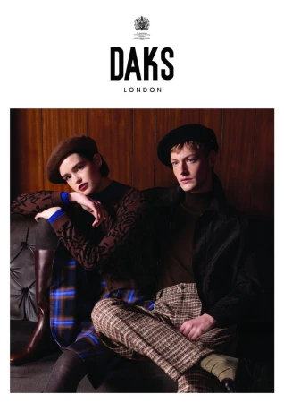 Two models pose for a fashion advertisement wearing berets and patterned clothing, seated on a tufted bench in warm, soft lighting.