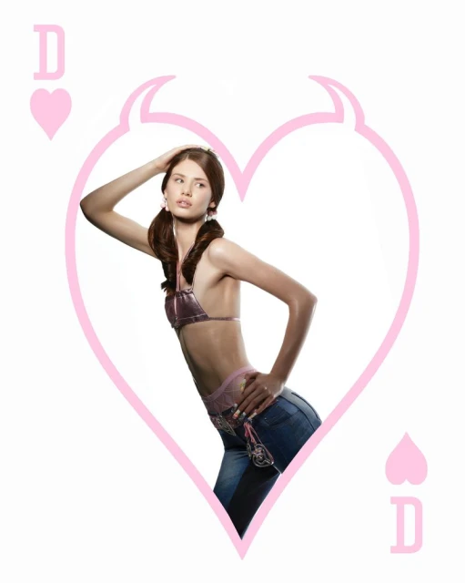 Young woman in bikini top and jeans poses within heart and devil horns design on a white background. Fashion and creative concept.