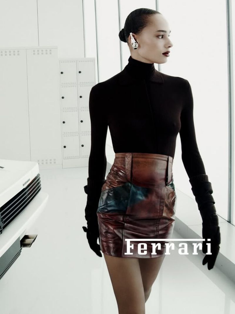Fashion shoot of a stylish woman in a black top and patchwork skirt in a modern white space with geometric lockers and windows.