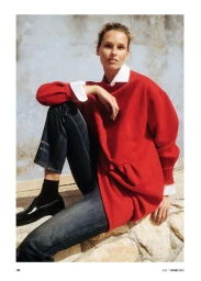 Model Mariina Keskitalo seated outdoors wearing a red sweater over a white shirt and denim jeans, photographed by Alex Waltl for Elle Germany.