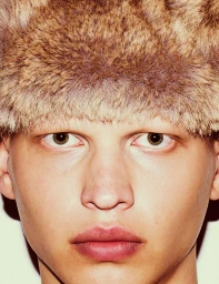 Close-up portrait of a model wearing a fluffy faux fur hat for Shadowplay Magazine under your skin project