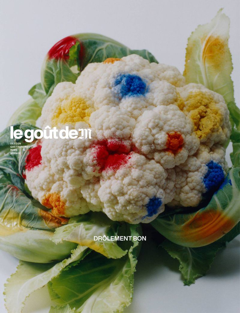 Still life of a cauliflower with colorful paint spots on a white background, food photography for a magazine cover.