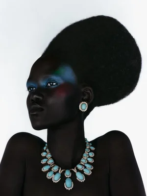 Model Caren Jepkemei wearing turquoise statement jewellery and vibrant eyeshadow against a white background for 10 Magazine
