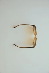 Top-down view of amber translucent eyeglasses resting on a plain white surface.