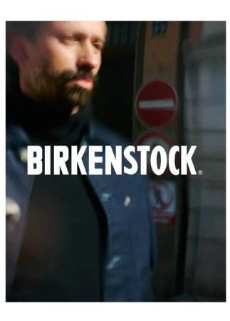 Adult male in an outdoor urban setting wearing a dark blue jacket and black turtleneck with Birkenstock logo visible in the center.