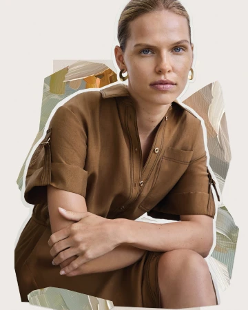 Close-up of a blonde woman in a brown collared dress with gold hoop earrings, posing against a neutral background with painted shapes.