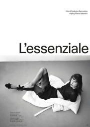 Black and white editorial fashion portrait of a female model reclining on a white pad against a grey studio floor, photographed by Federico Sorrentino.