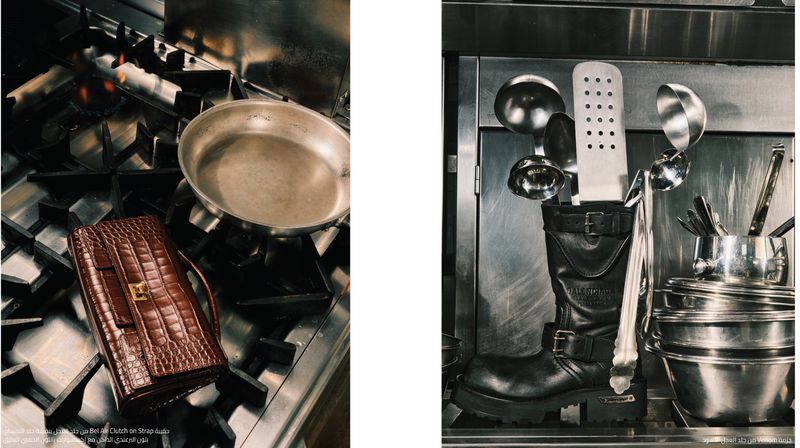 An elegant brown crocodile-skin clutch bag sits on a stainless-steel gas stove next to a silver cooking pan in a kitchen setting.