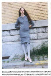 Model leaning against a yellow brick and stone exterior wall wearing a grey midi dress and patterned tights