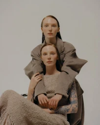 Two female models posing together in neutral knitwear against a plain studio background for Marie Claire Czech Republic.