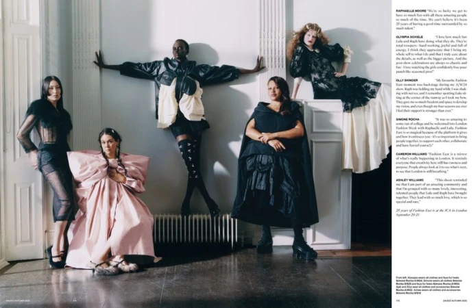 A group of five fashion models in dramatic couture pose together indoors with editorial lighting, showcasing avant-garde clothing designs.