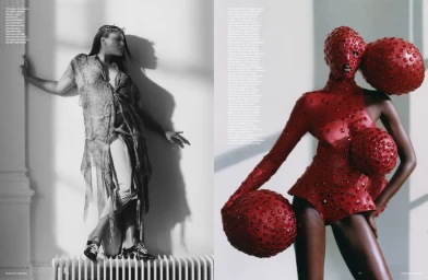 Two models pose in a minimalist white interior, one in a snakeskin print outfit and one in a red studded bodysuit.