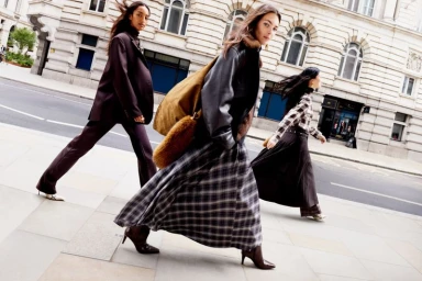 Three models walking on a city street wearing fall apparel for the H&M F/W 2025 campaign photographed by Anthony Seklaoui