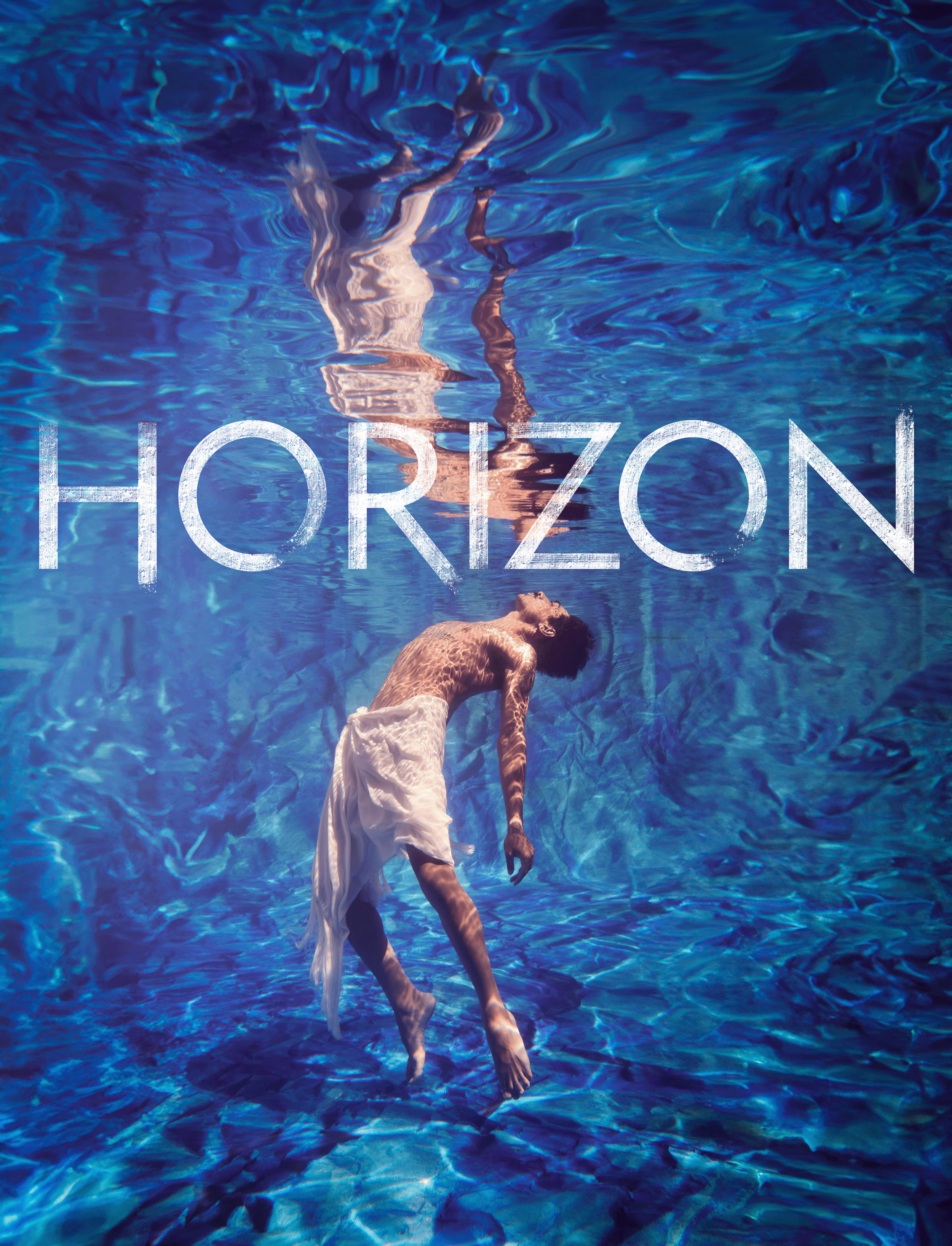 Underwater view of an adult male with light fabric floating in blue water, reflecting off the surface in a stylized photograph.