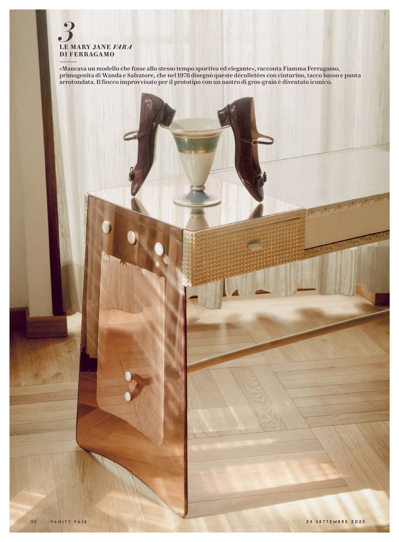 Mary Jane heels and a vintage vase sit atop a mirrored table, with a wooden floor adding warmth to this fashion editorial.