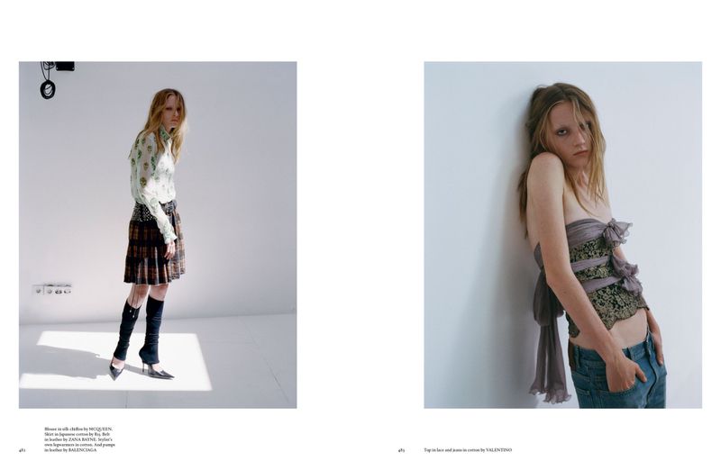 Fashion editorial shot: Two slender women in designer outfits against a plain white backdrop, showcasing contrasting styles and poses.
