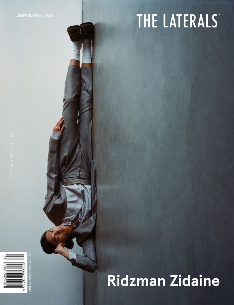 Magazine cover featuring a man in a suit balancing with his feet against a concrete wall and the magazine's title, 'The Laterals.'