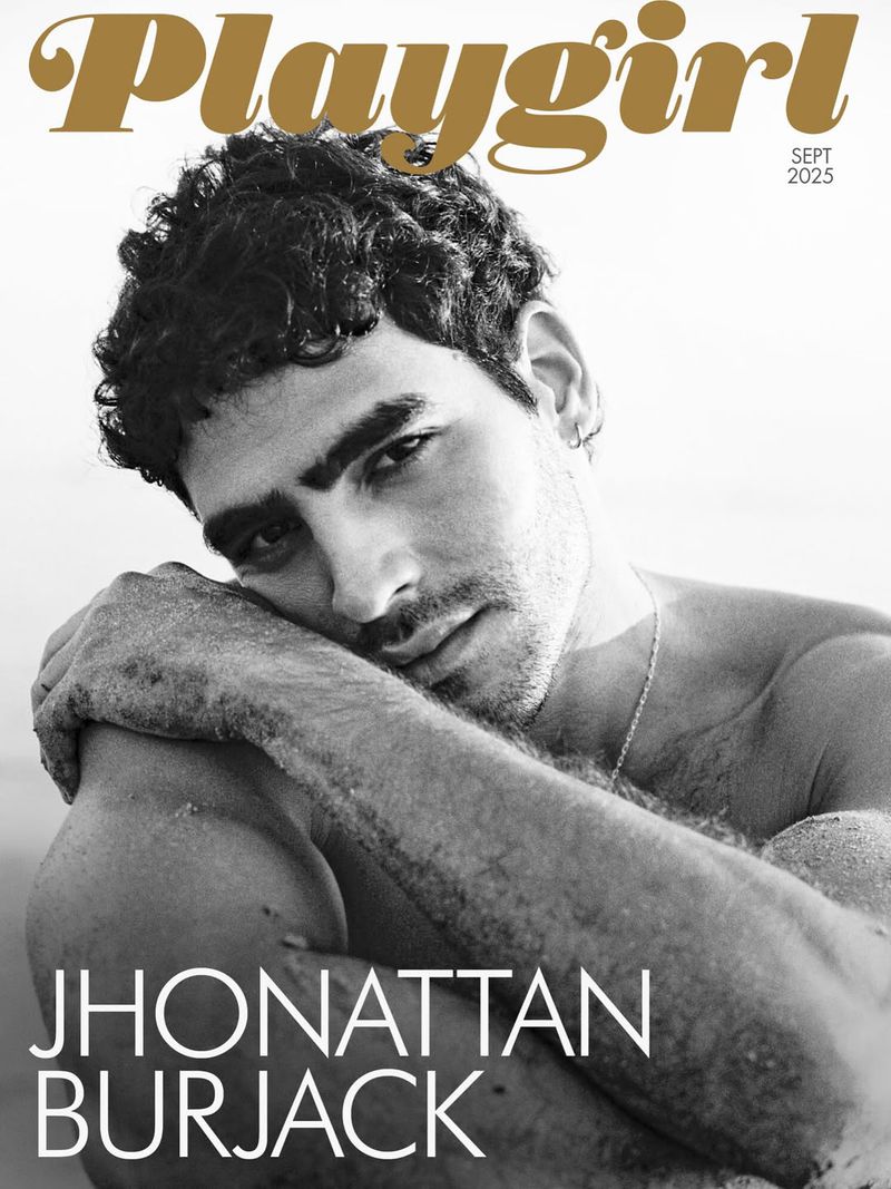 Black and white magazine cover featuring a shirtless male model with dark curly hair resting his head on his arm, looking at the camera.