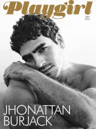 Black and white magazine cover featuring shirtless model Jhonattan Burjack resting his head on a sand-covered arm.