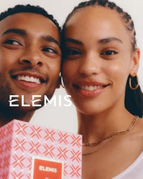 Close-up portrait of a smiling black man and woman posing together with a pink patterned gift box for ELEMIS.