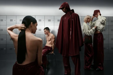 Group of models posing in a locker room setting wearing burgundy and pale green garments, photographed by William Arcand for Rains x Umbro.