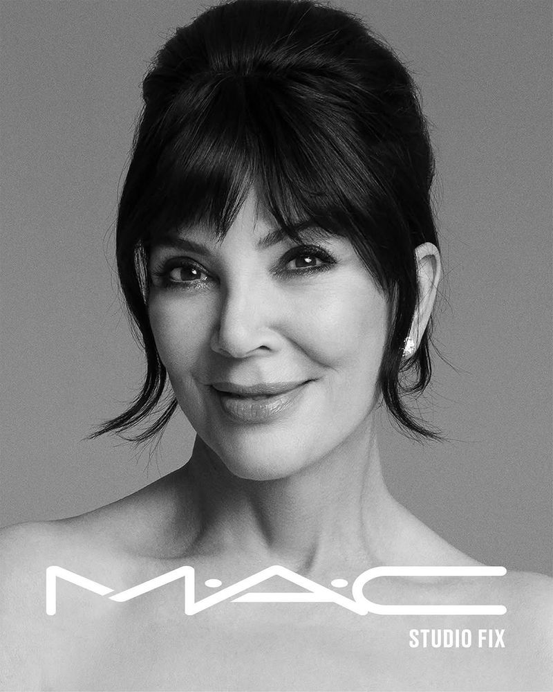 Black-and-white headshot of an adult woman with dark hair and bangs, smiling slightly in a beauty ad with the MAC cosmetics logo.
