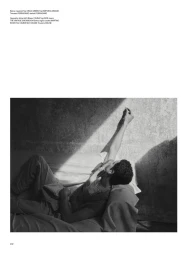 Model Sekhou Drame reclines on a daybed with one arm raised into a beam of sunlight against a textured wall for Port Magazine.