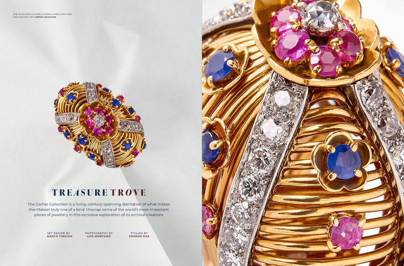 High-angle shot of a gold ring with rubies, sapphires, and diamonds on a white surface, showcased in a magazine editorial for luxury jewellery.
