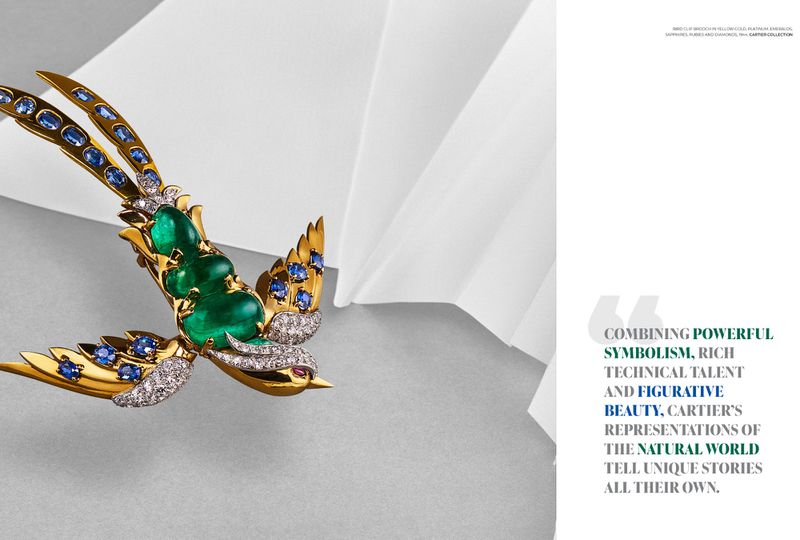 Bird brooch in yellow gold, platinum, emeralds, sapphires, rubies and diamonds on a white and gray backdrop. Jewelry advertisement.
