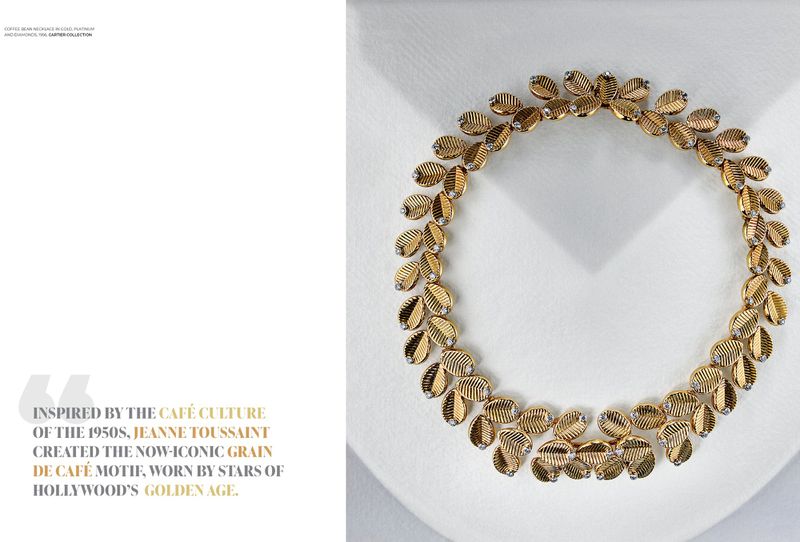 Gold necklace with leaf-shaped links and diamond accents, displayed on a white surface, showcasing its intricate design and craftsmanship.